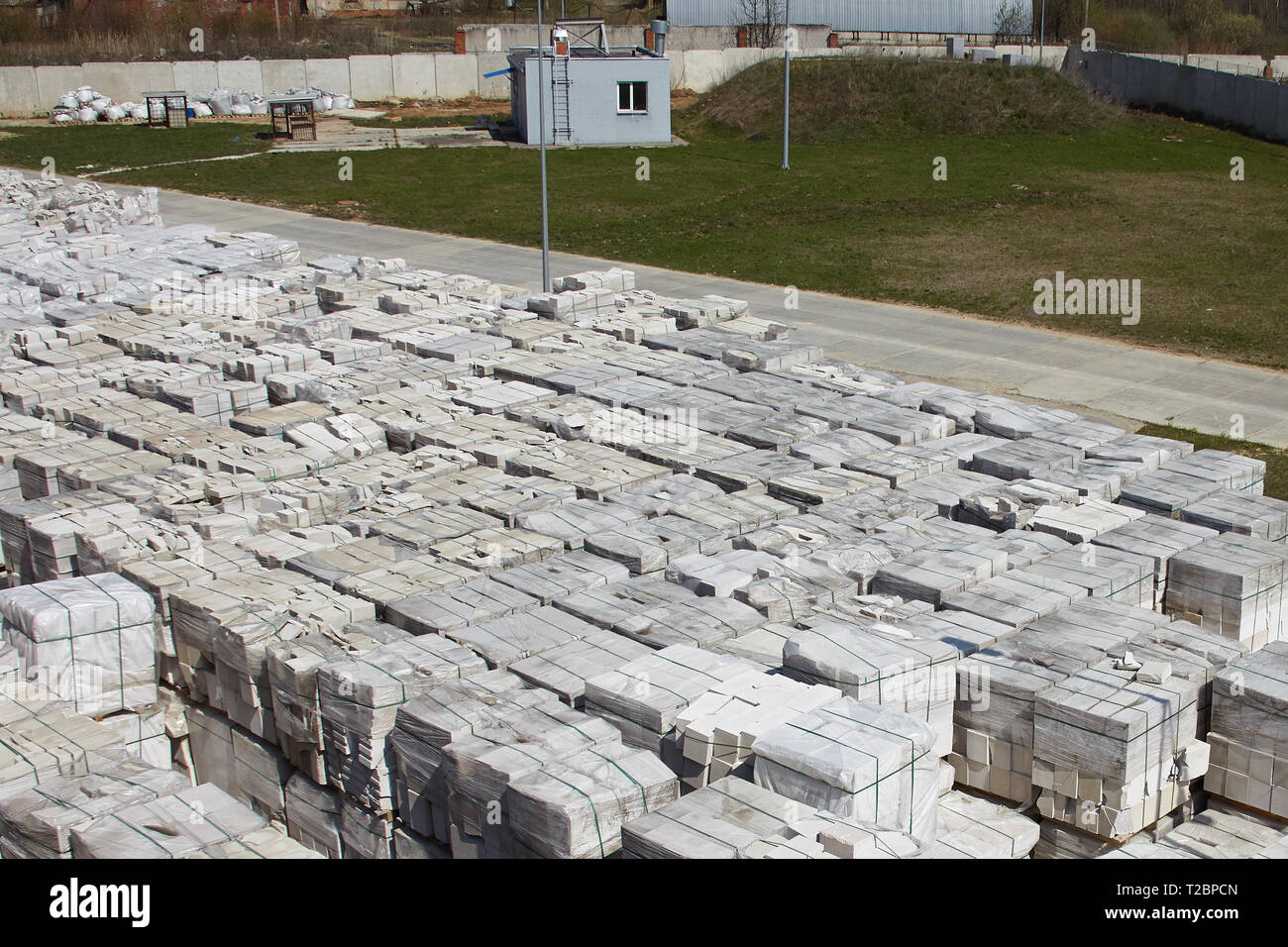 Molti pacchetti di autoclavato calcestruzzo aerato su pallet mettere uno sull'altro su un esterno di magazzino di fabbrica. Vista superiore della zona industriale. Foto Stock