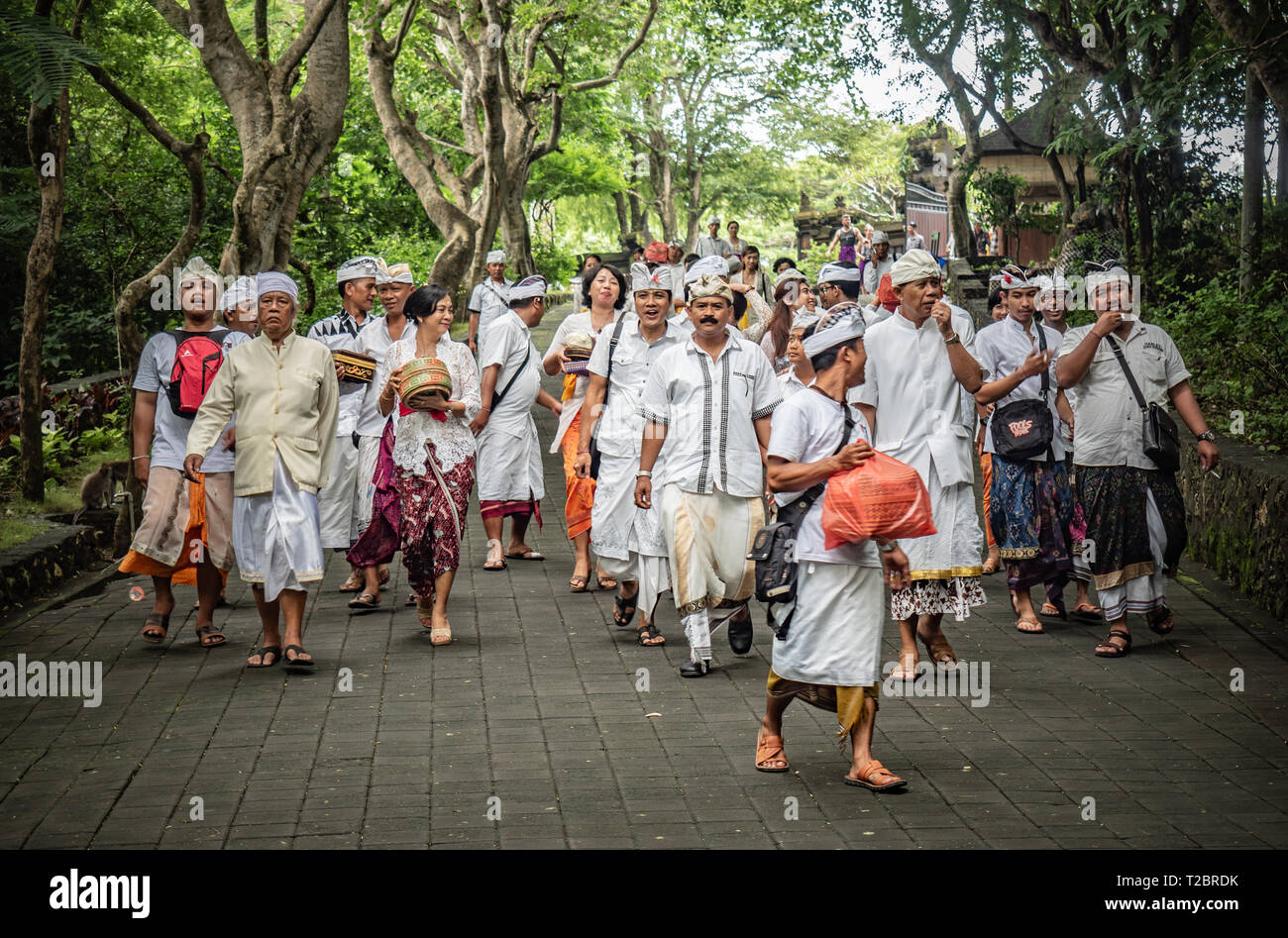 Popolo Balinese, famiglie locali, indossa tutto bianco, in processione alla pura Luhur Tempio di Uluwatu, andando a pregare e a donare alimenti di mare spiriti. Bali Foto Stock