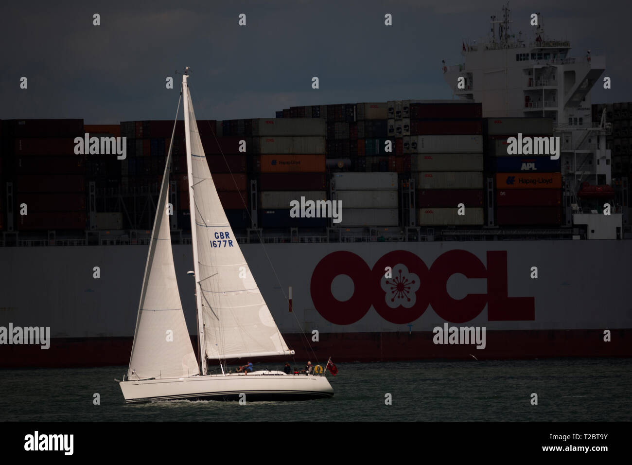 Yacht,passando,Contenitore, nave, OOCL, Bruxelles, lasciando, Southampton, terminale, leggermente, caricato, box, esportare, importare il Solent, Cowes, isola di Wight Foto Stock