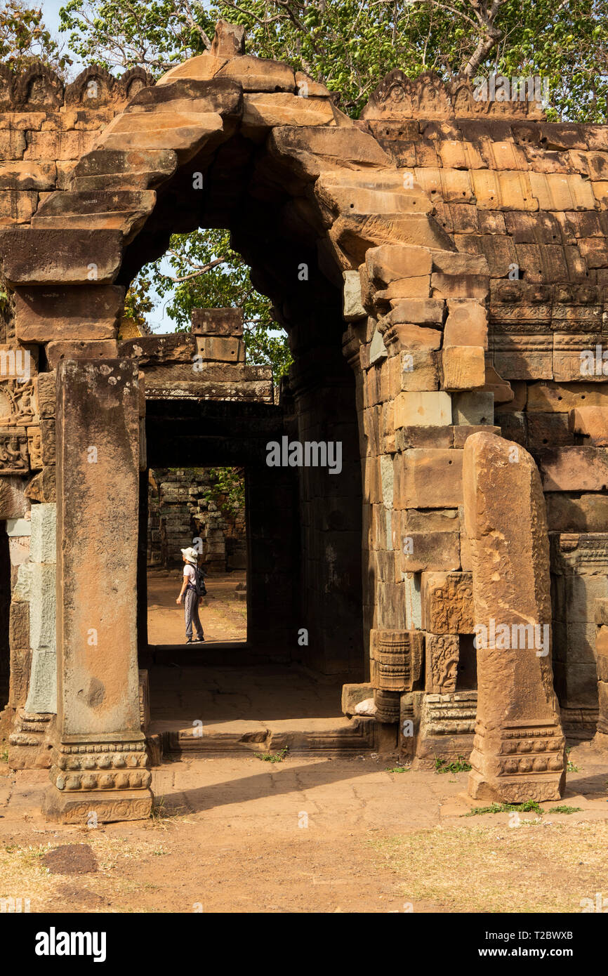 Cambogia, Kampong () Kompong Cham, Banteay Prei Nokor, senior tourist in gateway attraverso le antiche pareti di pietra del centro storico di Wat Nokor tempio Foto Stock