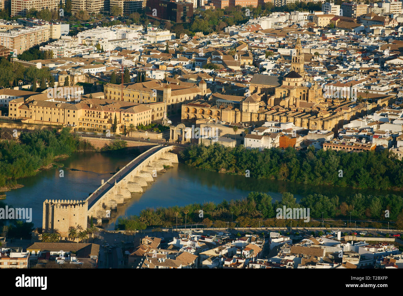 VISTA AEREA. Complesso storico di edifici moreschi e cristiani lungo il fiume Guadalquivir. Cordoba, Andalusia, Spagna. Foto Stock