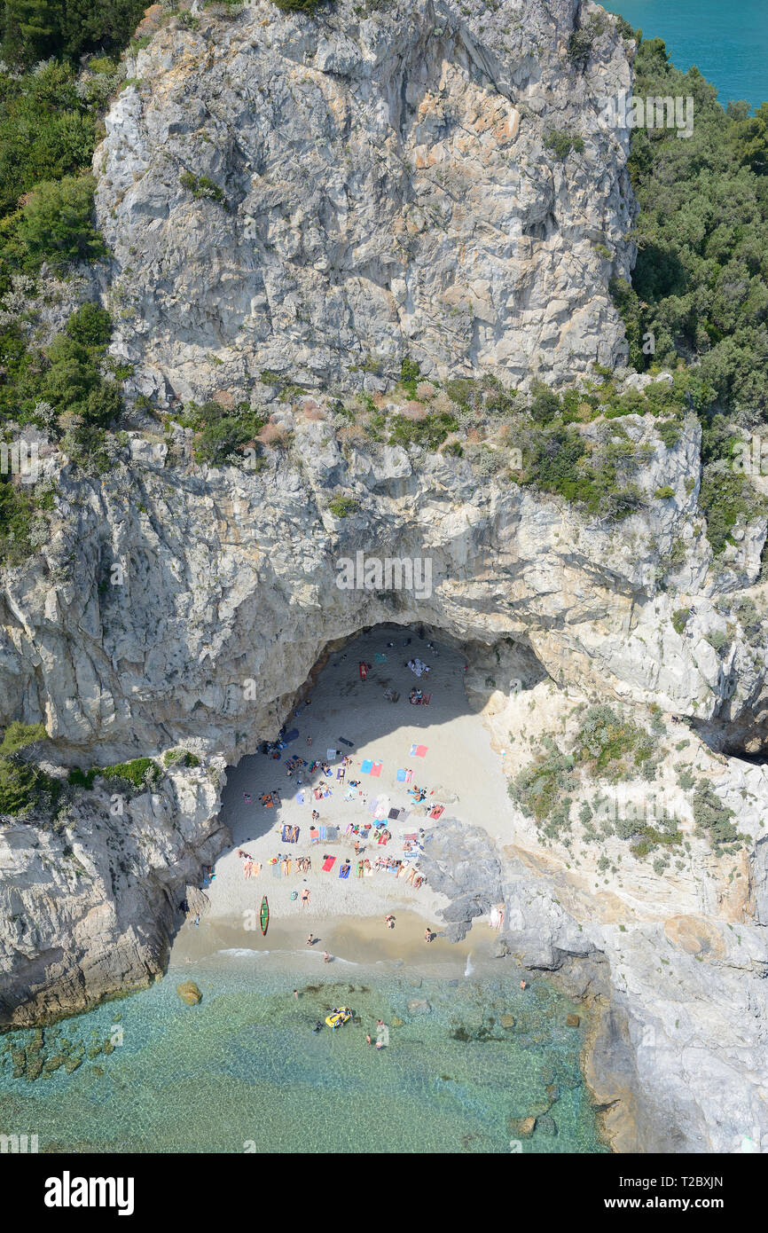 VISTA AEREA. Scogliera sul mare con una grande grotta ai suoi piedi che offre un ambiente pittoresco per i bagnanti. Varigotti, Provincia di Savona, Liguria, Italia. Foto Stock