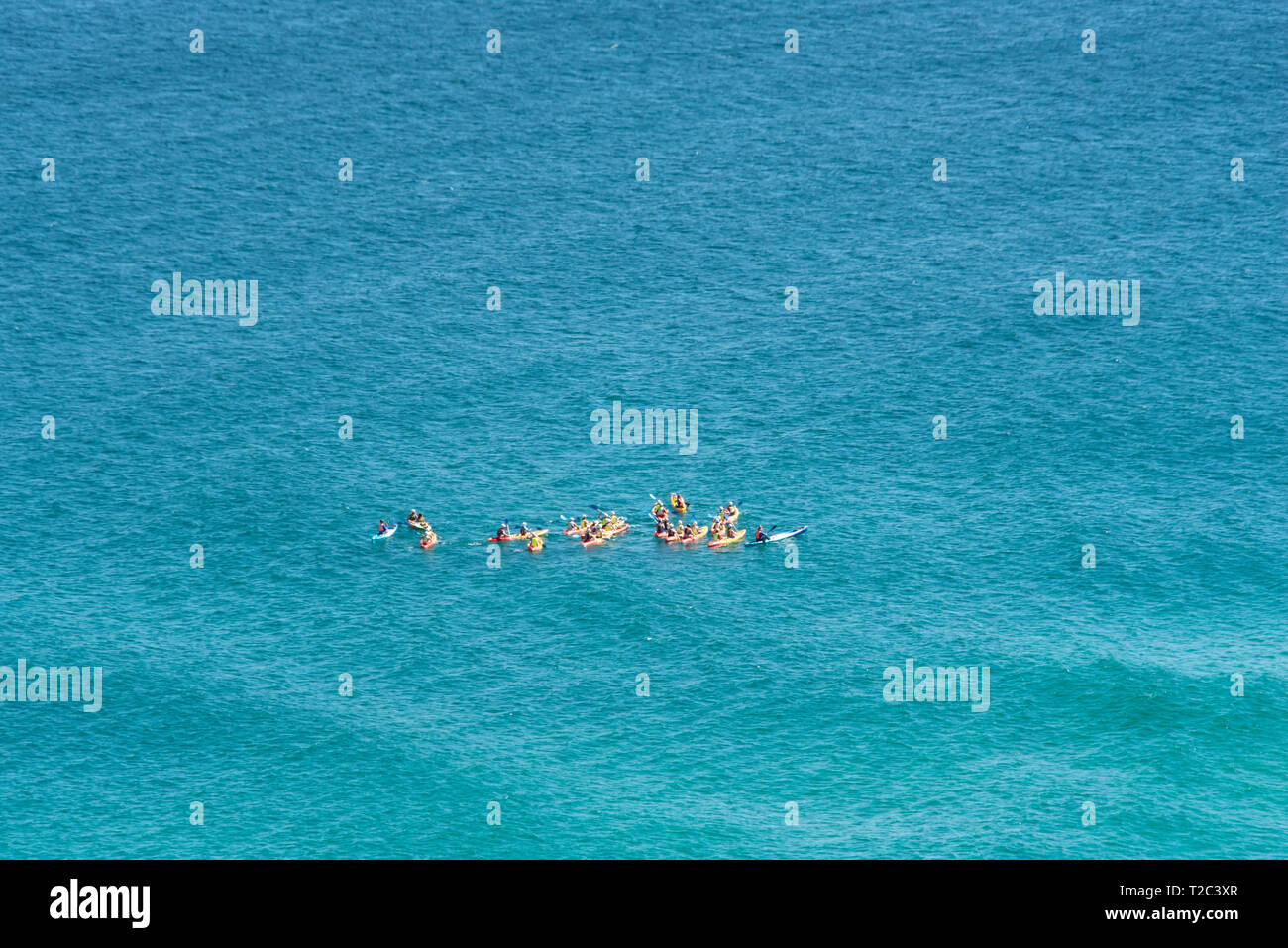 Kayakers godendo della splendida acquamarina acque su un giorno perfetto di Byron Bay. Foto Stock