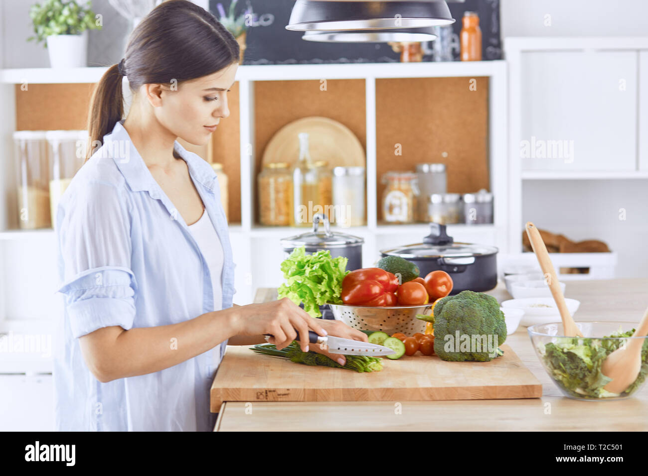 Una giovane donna prepara piatti di cucina. Cibo sano - insalata di verdure. La dieta. Il concetto di dieta. Uno stile di vita sano. Cuocere a casa. Cuocere. Foto Stock