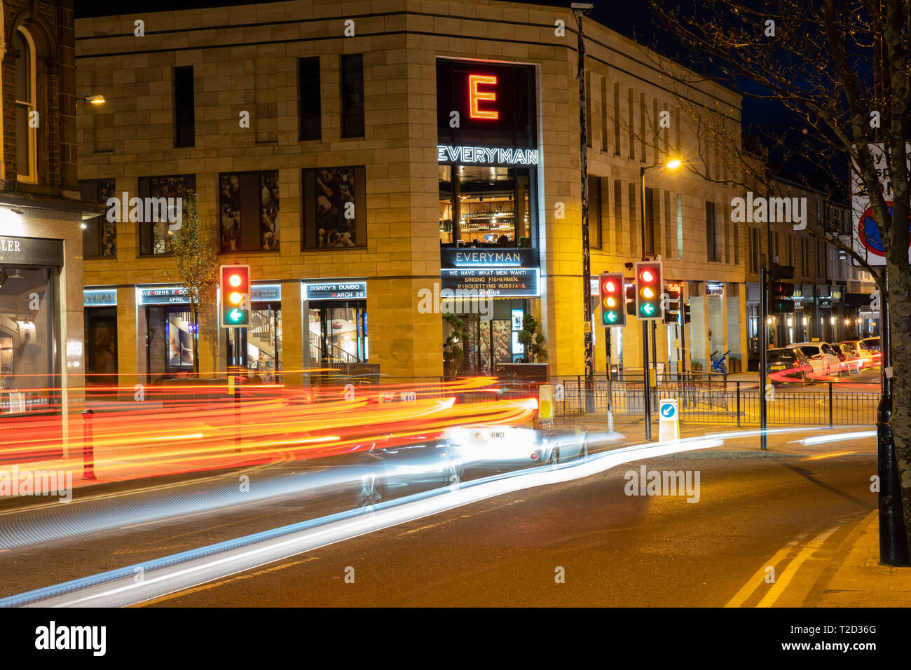 Luci di coda e fari a traffico urbano di notte con Everyman Cinema Complex sullo sfondo Harrogate, North Yorkshire, Inghilterra, Regno Unito. Foto Stock