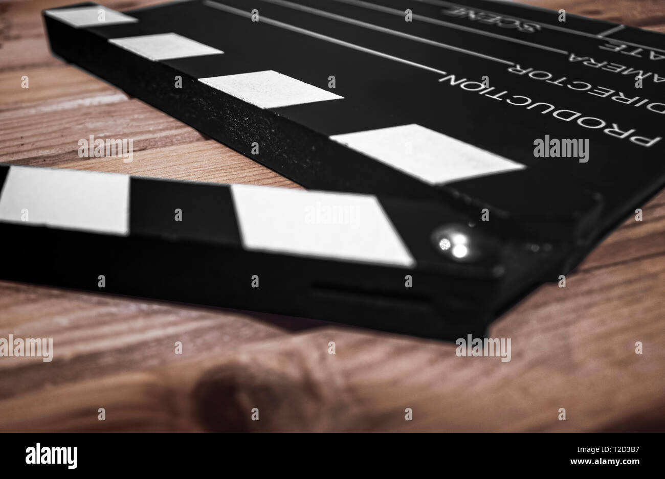 Messa a fuoco selettiva di un battaglio di bordo su una superficie di legno, cinema e videomaking concep Foto Stock