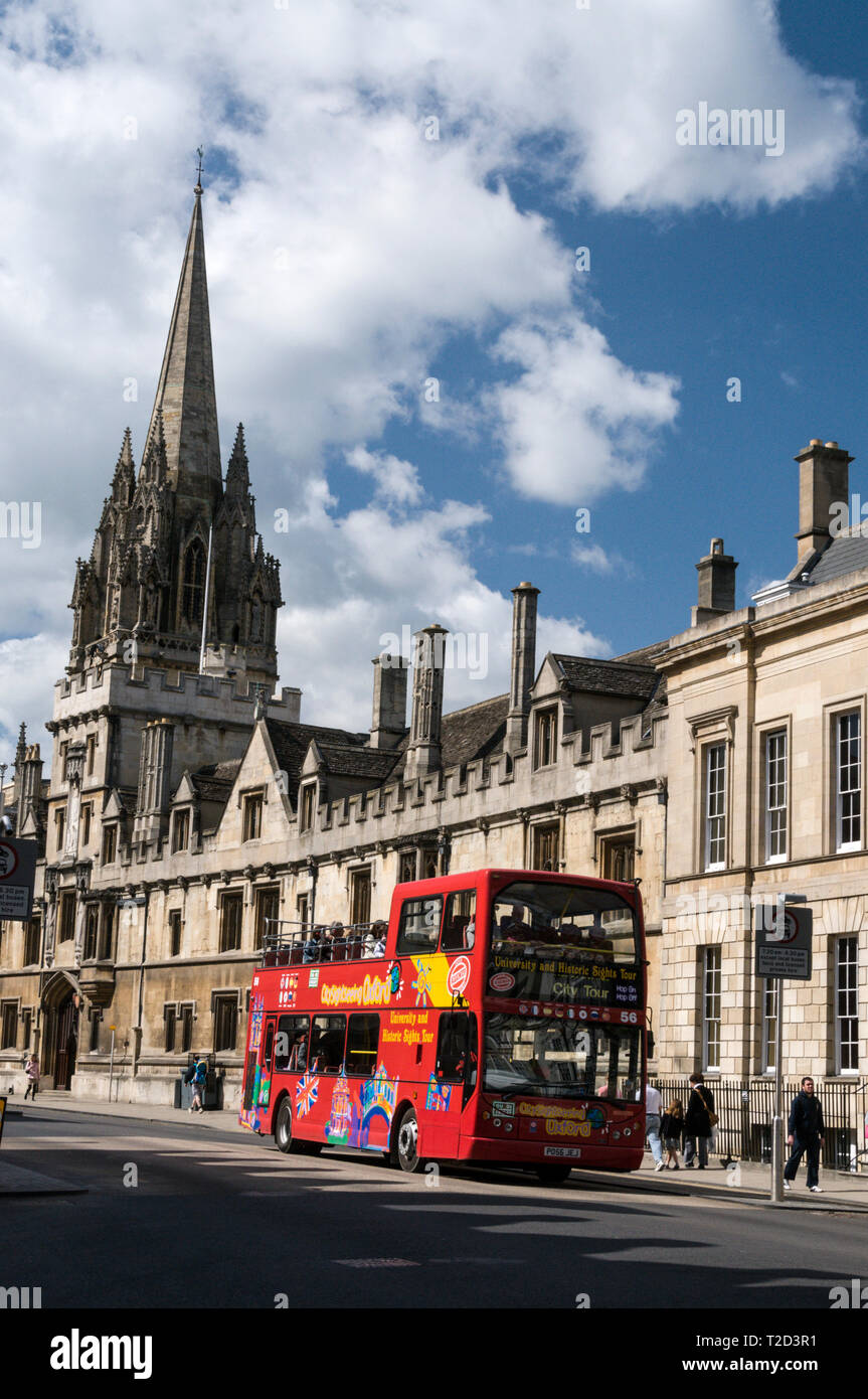 Un hop on-hop off-autobus turistico passando l'università chiesa di Santa Maria Vergine, nella High Street a Oxford, Gran Bretagna Foto Stock