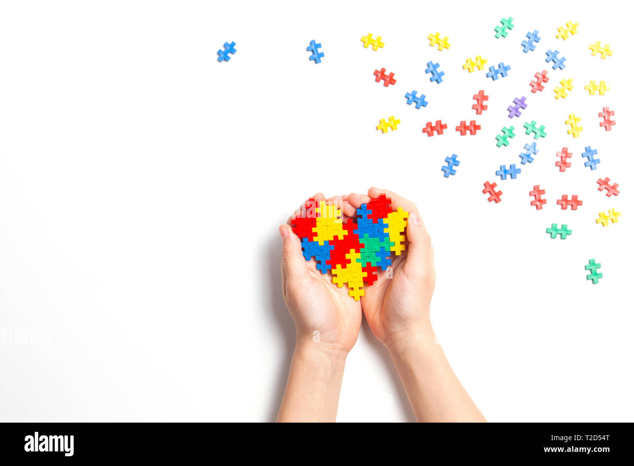 Kid mano azienda cuore colorato su sfondo bianco. Mondo autismo consapevolezza giorno di concetto Foto Stock