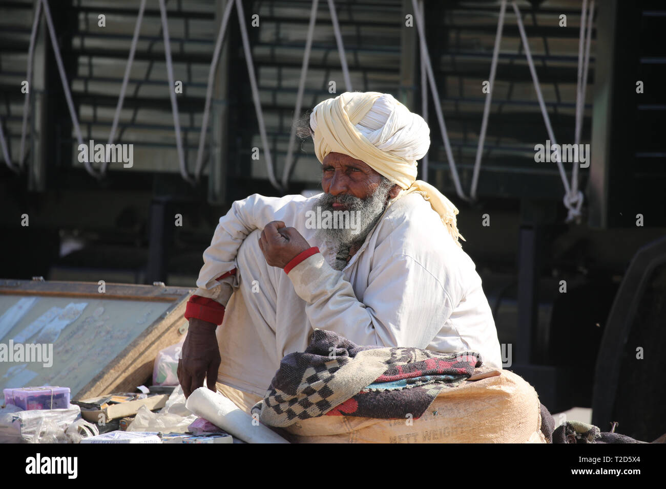 Il vecchio uomo seduto e in vendita alcuni Produkts sul mercato in Jaisalmer - Rajasthan Foto Stock