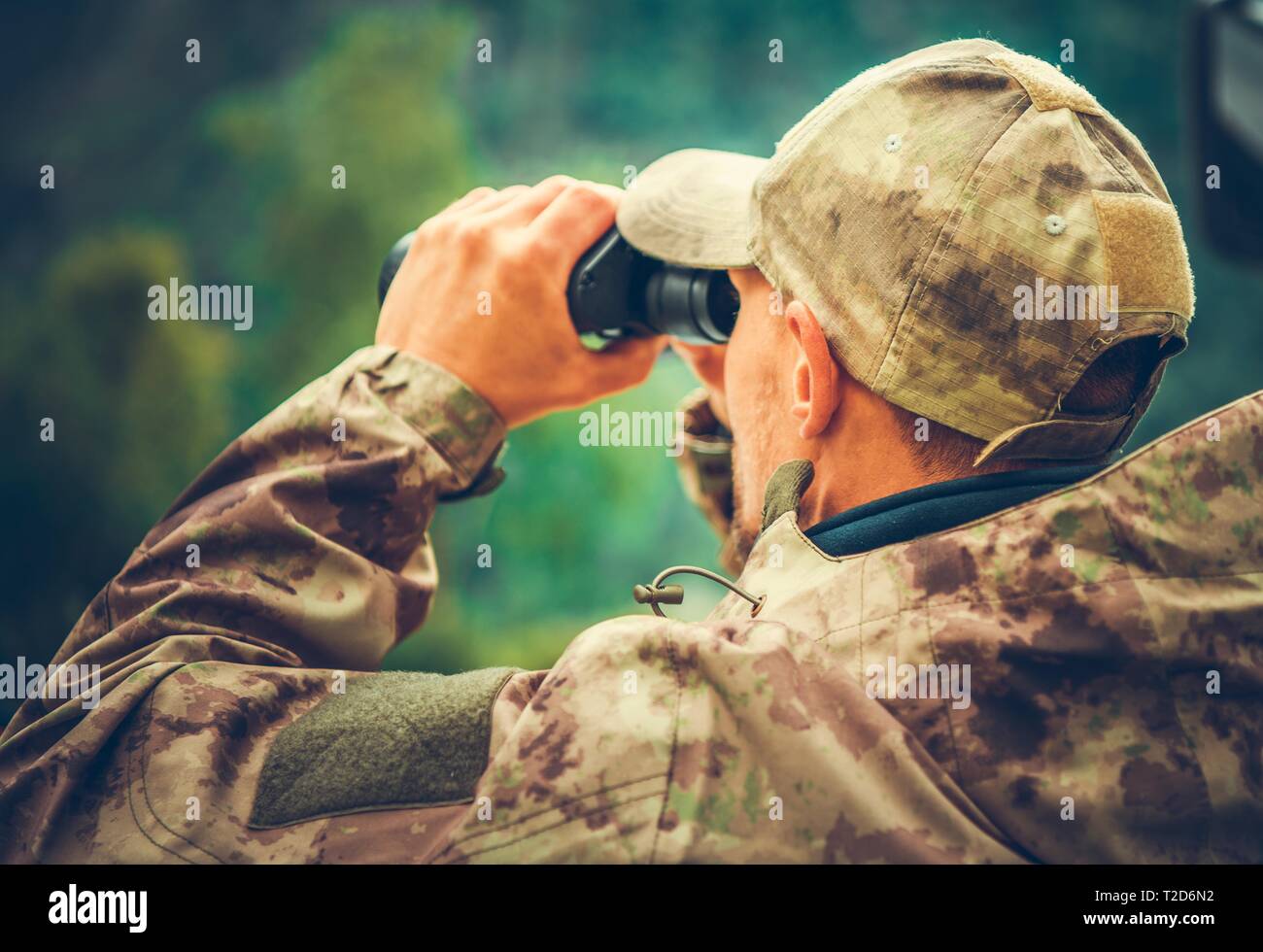Il cacciatore caucasica Spotting gioco utilizzando un binocolo. Stagione di caccia. Foto Stock