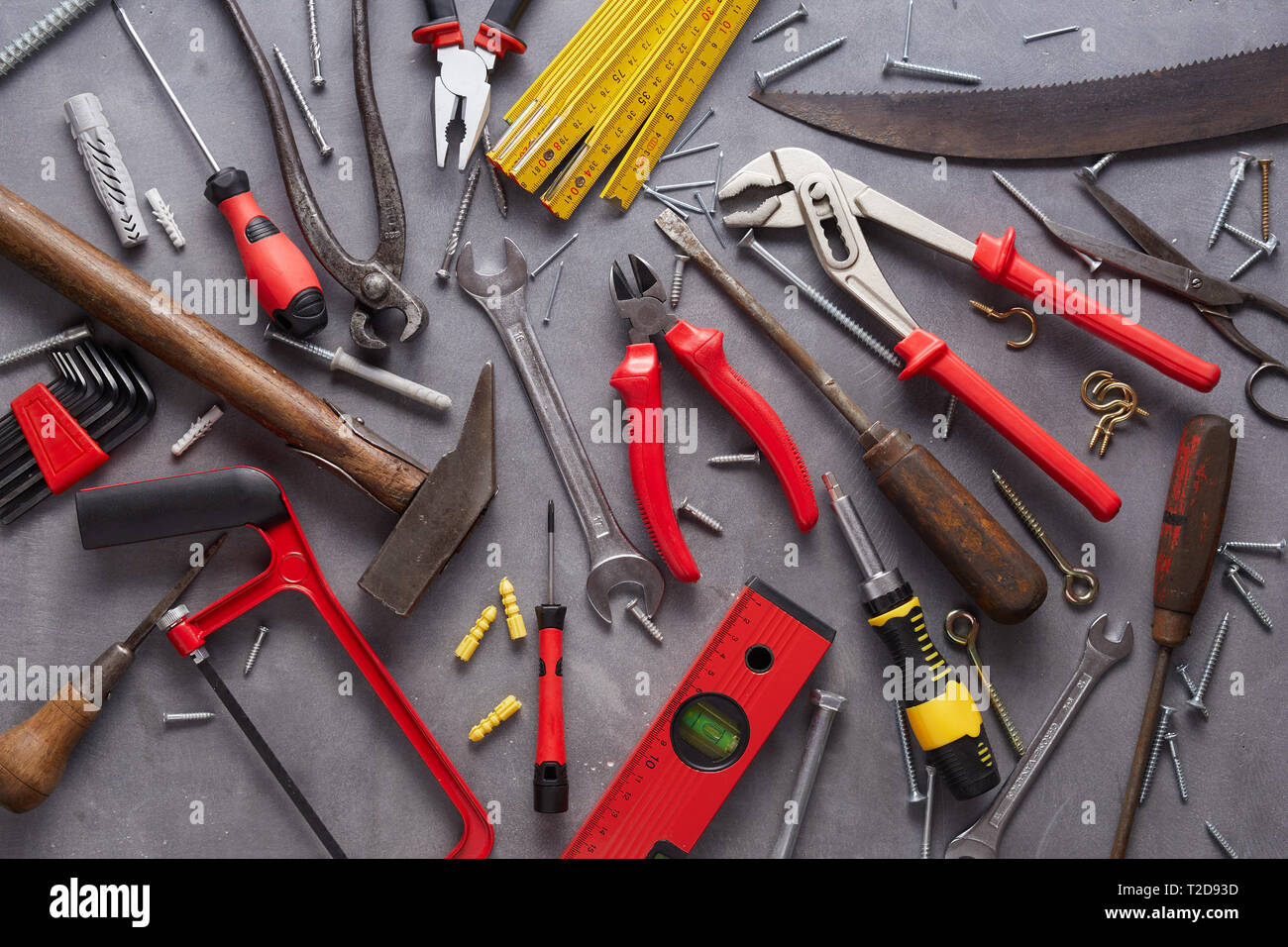 Varietà di vecchio vintage e arredamento moderno di utensili a mano disposto come un piatto ancora laici vita sul grigio in un DIY e concetto di ristrutturazione Foto Stock