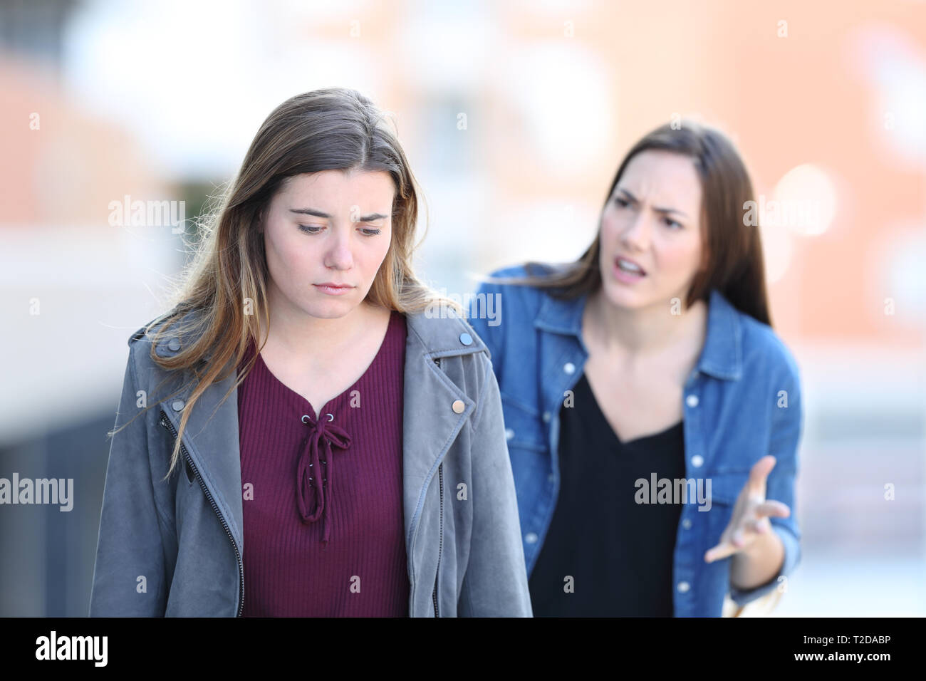 Arrabbiato ragazza scolding ha sottolineato il suo amico a piedi in strada Foto Stock