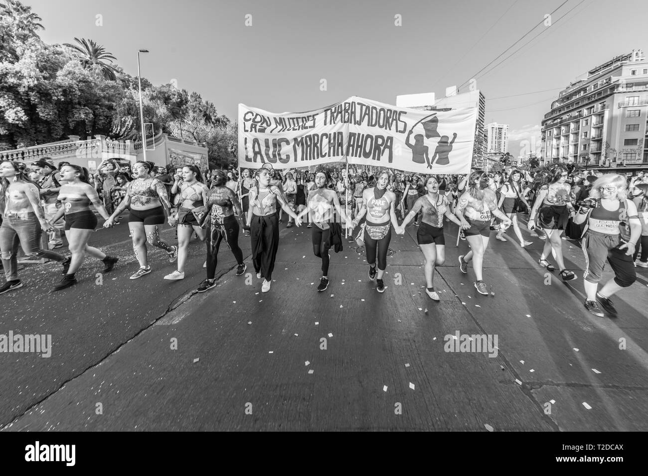 Una vista della città di Santiago stradine del centro durante la giornata della donna di dimostrazione. Persone che trasportano protester segni durante la giornata della donna 8M Foto Stock