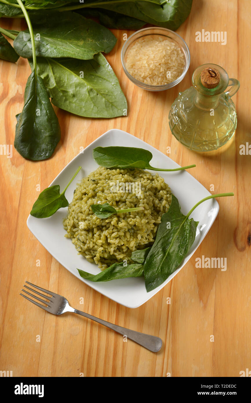 Italian risotto con gli spinaci nel piatto bianco - ricetta vegetariana - primo piano Foto Stock