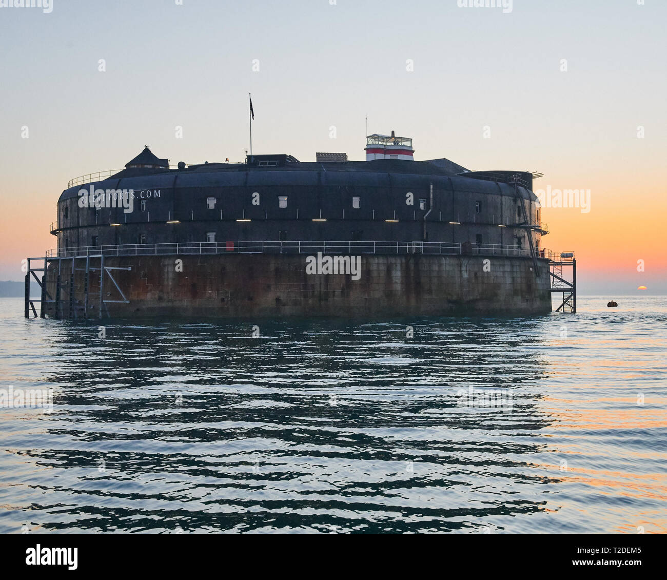 Gli anni sessanta e granito e ferro costruita No Mans Land Sea Fort nella luce del tramonto. Ingegneria vittoriano di difendere la Royal Navy fleet al di ancoraggio Foto Stock