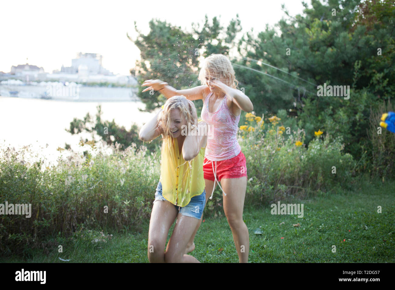 Gli amici di gettare acqua palloncini a vicenda ridendo hysterically Foto Stock