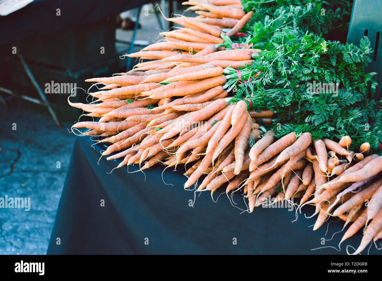 Centinaia di prodotti freschi e le materie prime per le carote sono in posa per la vendita in un grappolo in un mercato degli agricoltori Foto Stock