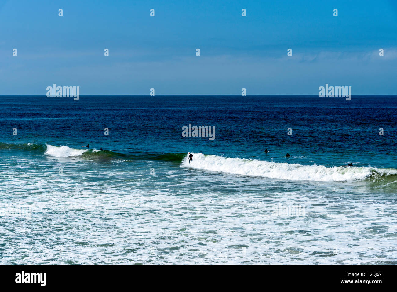 Le onde del mare di rottura di rottura sul litorale sotto il luminoso cielo blu. Foto Stock