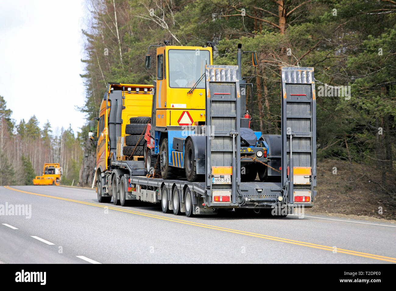 Salo, Finlandia - 29 Marzo 2019: Giallo Volvo FH carrello terminale tira il trattore su un rimorchio Noteboom in convoglio con un altro carrello della stessa società. Foto Stock