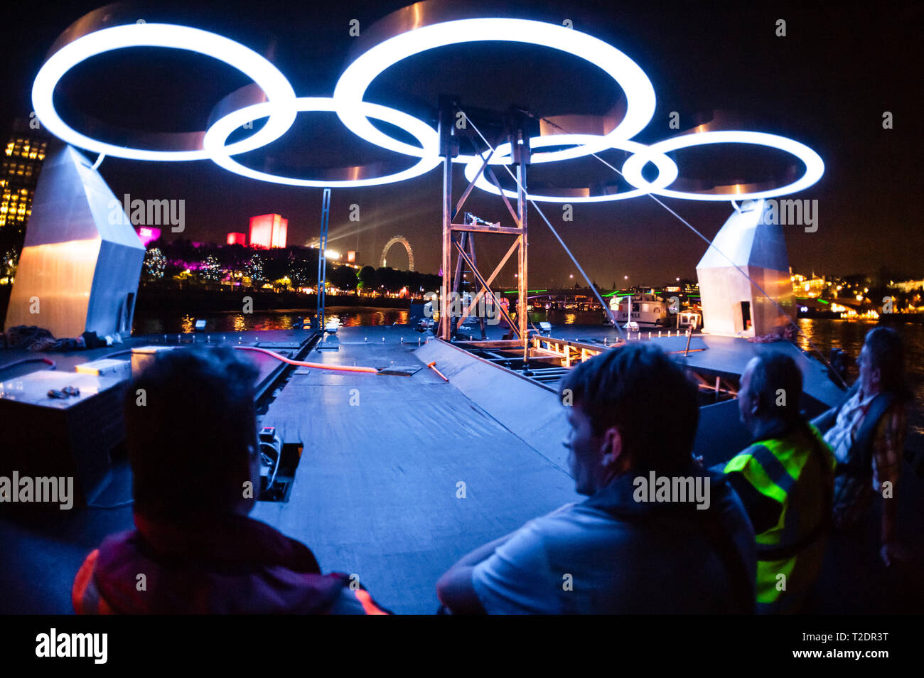 Gli anelli olimpici illuminare i lavoratori che si spostano il 'Ring sul fiume' presentano, da Greenwich a South Bank, durante i Giochi Olimpici di Londra 2012. Foto Stock