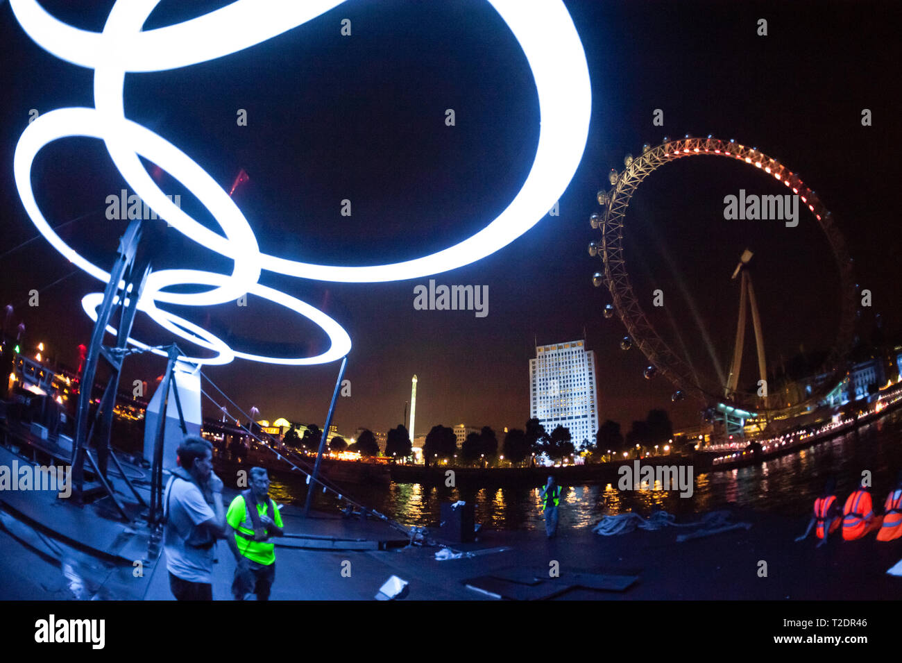 Gli anelli olimpici illuminare i lavoratori che si spostano il 'Ring sul fiume' presentano, da Greenwich a South Bank, durante i Giochi Olimpici di Londra 2012. Foto Stock