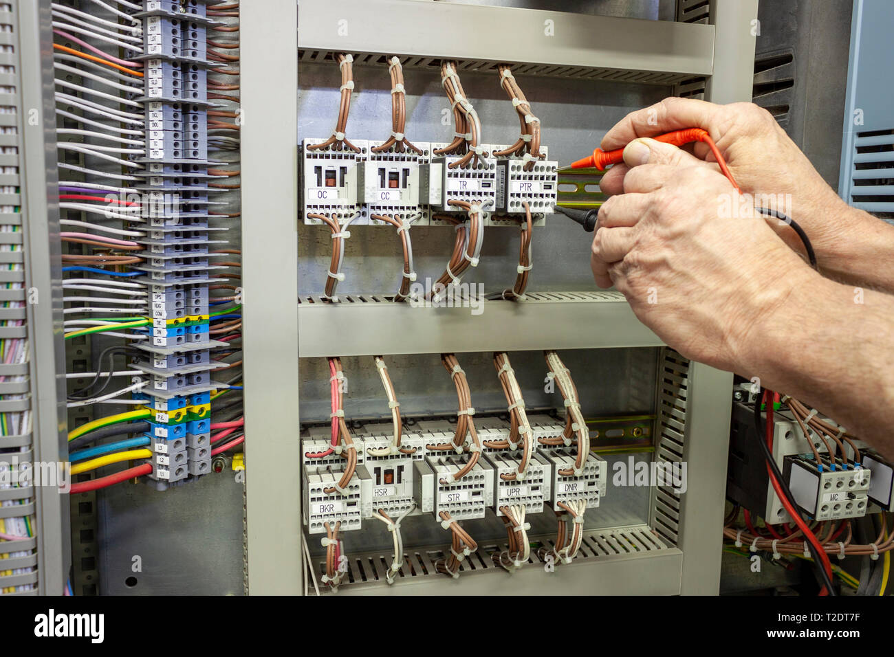 Ingegnere elettrico test di un contattore in un pannello di controllo Foto Stock