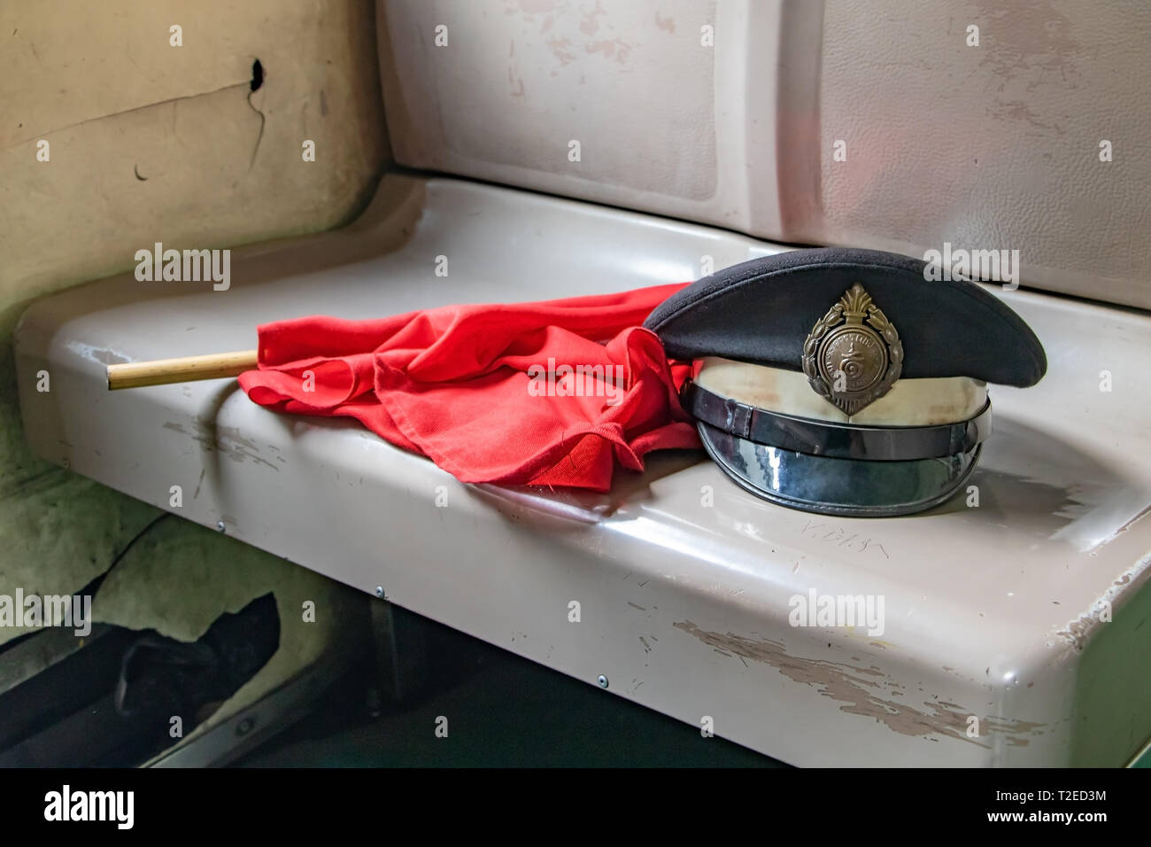 SAMUT SONGKHRAM, Thailandia, Ott 06 2018, il cappuccio del ferroviere tailandese con la bandiera rossa che giace sul sedile obsoleti nel vecchio carro. Foto Stock