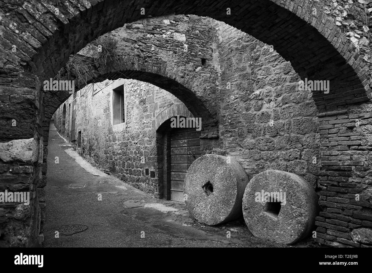 Archi e macina, Vicolo Capassi, San Gimignano, Toscana, Italia. Versione in bianco e nero Foto Stock