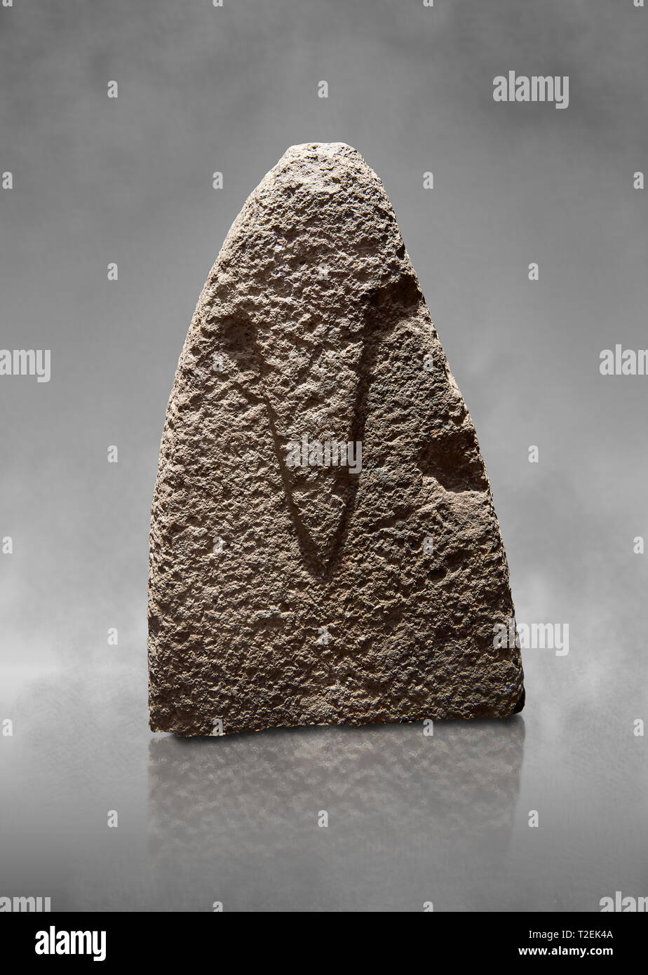 La sezione superiore di un tardo Neolitico europeo Menhir preistorici di pietra permanente con intagli sulla sua faccia laterale. La rappresentazione di un maschio stylalised fig Foto Stock