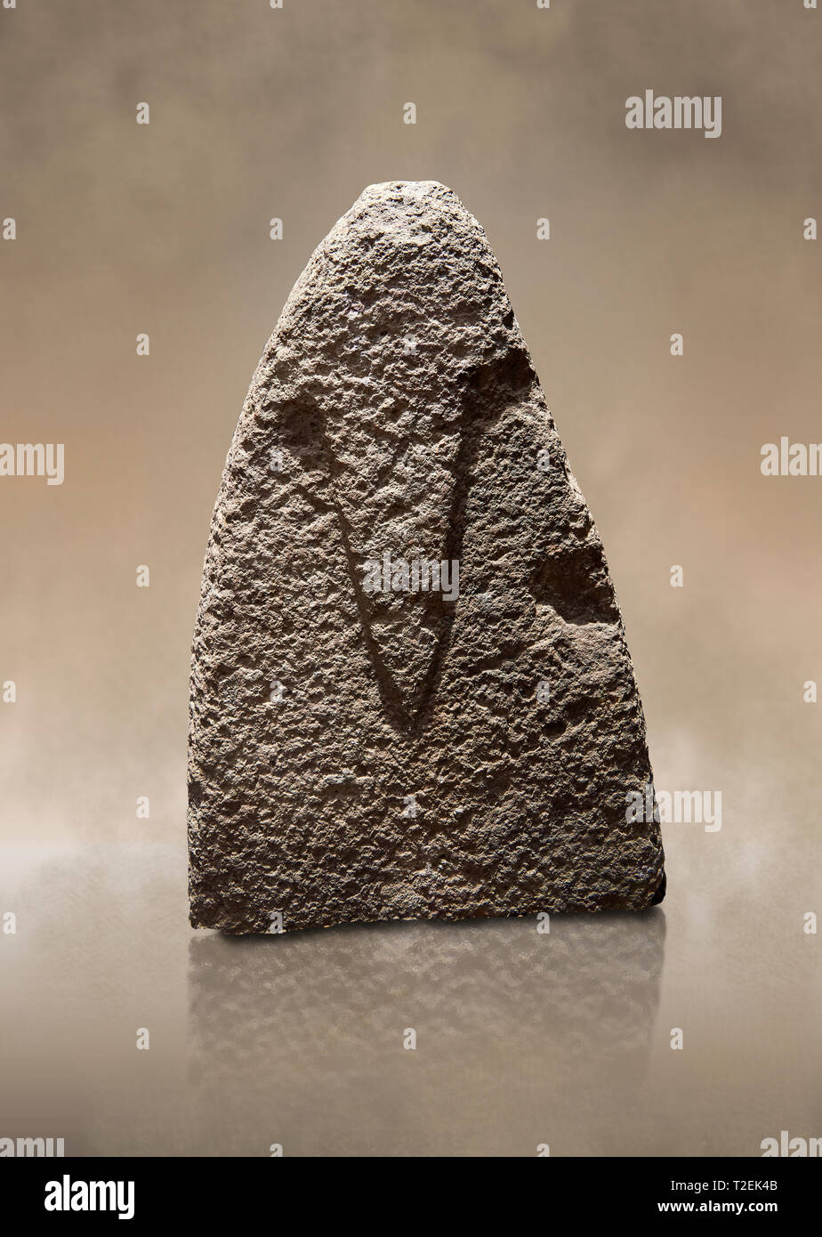 La sezione superiore di un tardo Neolitico europeo Menhir preistorici di pietra permanente con intagli sulla sua faccia laterale. La rappresentazione di un maschio stylalised fig Foto Stock