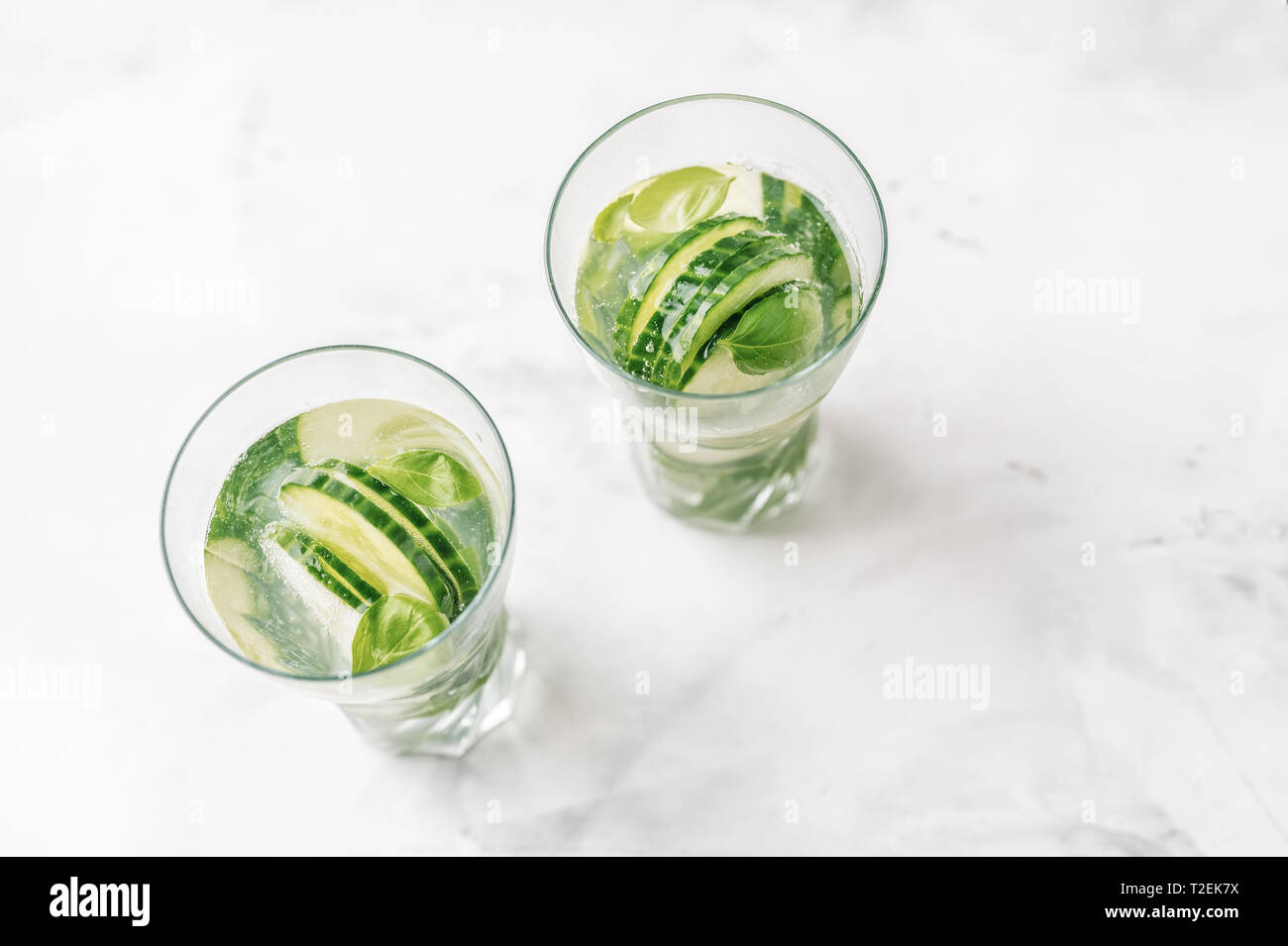 Vista dall'alto di due bicchieri con detox acqua infusa con il cetriolo e basilico Foto Stock