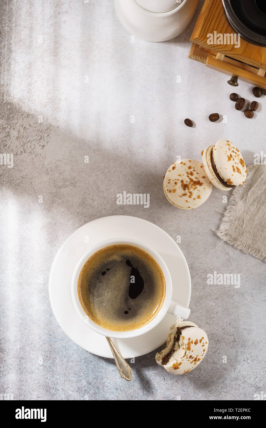 Il caffè nero e macarons francese. Mattina di sole prima colazione concetto. Foto Stock
