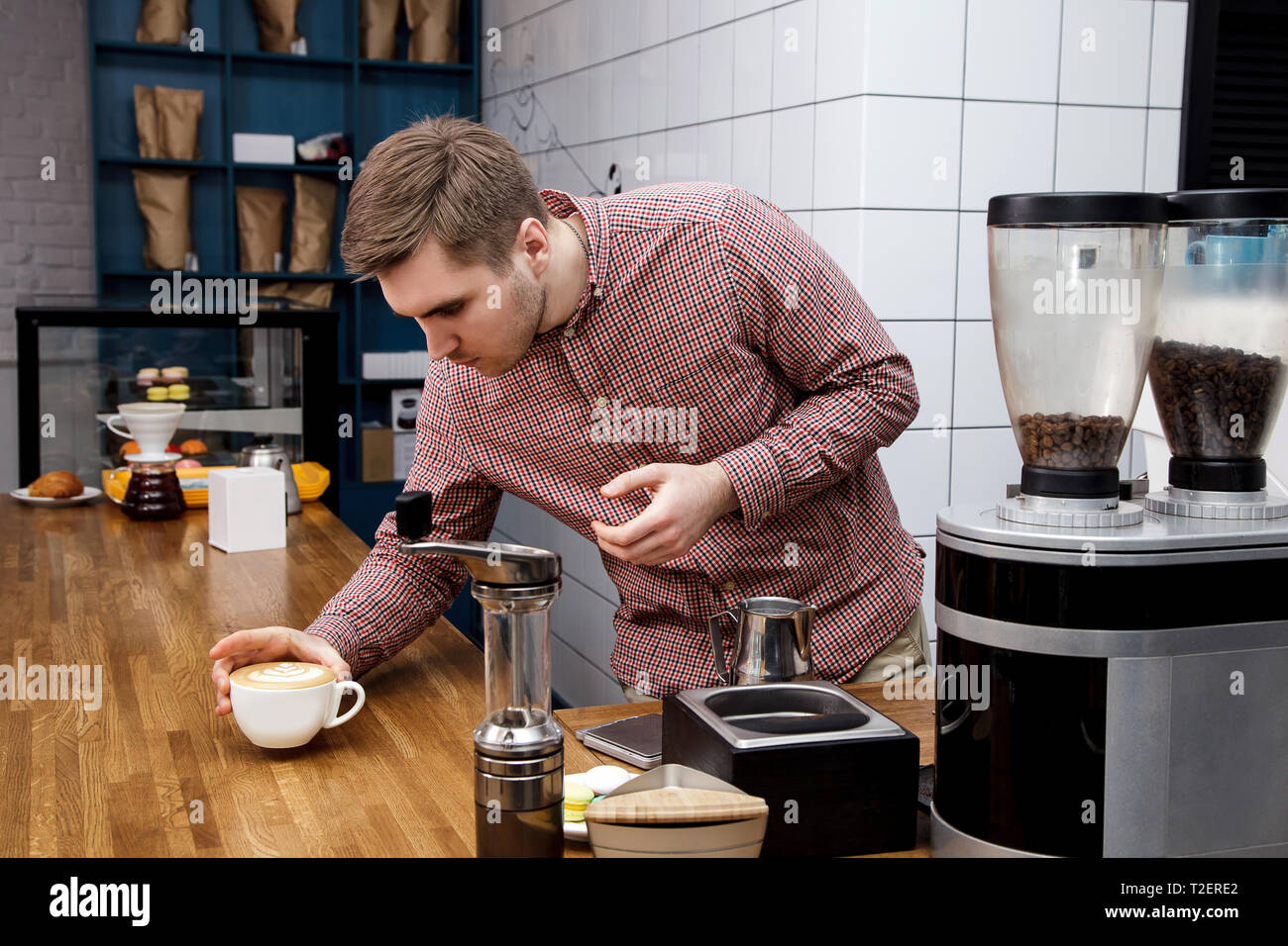 Bel giovane barista hipster fare il caffè per i suoi clienti nel cafe'. Foto Stock