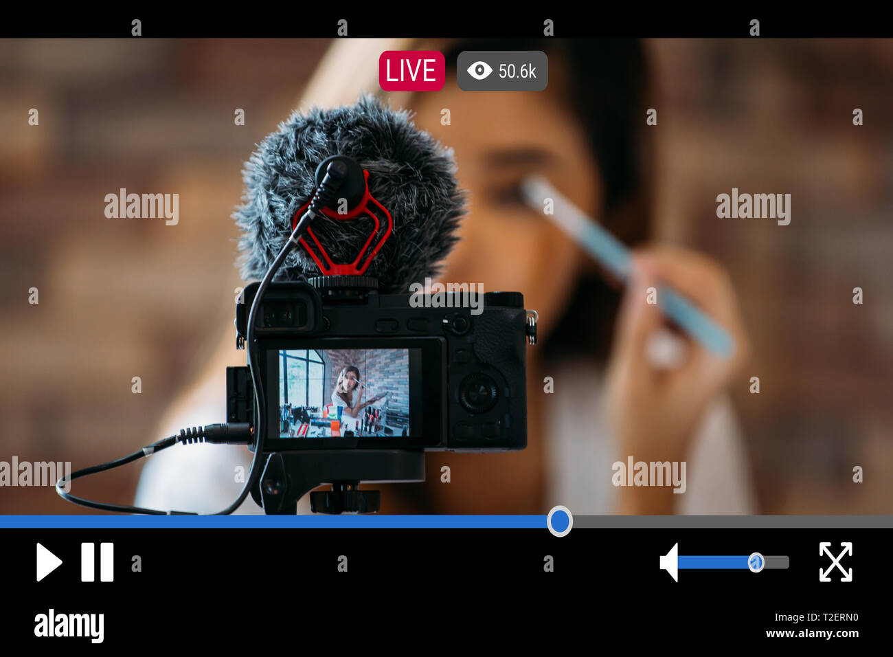 Giovane donna bella la registrazione live streaming di video per il trucco e cosmetici a scopo commerciale online con video interfaccia player Foto Stock