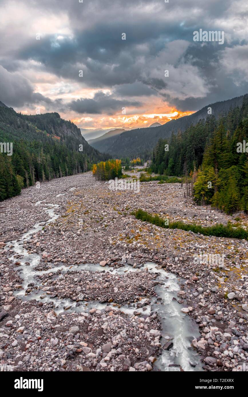 Riverbed, Nisqually fiume, con piccolo trafilamento, all'orizzonte il tramonto, drammatica nuvole con montagne e colline, il Parco Nazionale del Monte Rainier Foto Stock