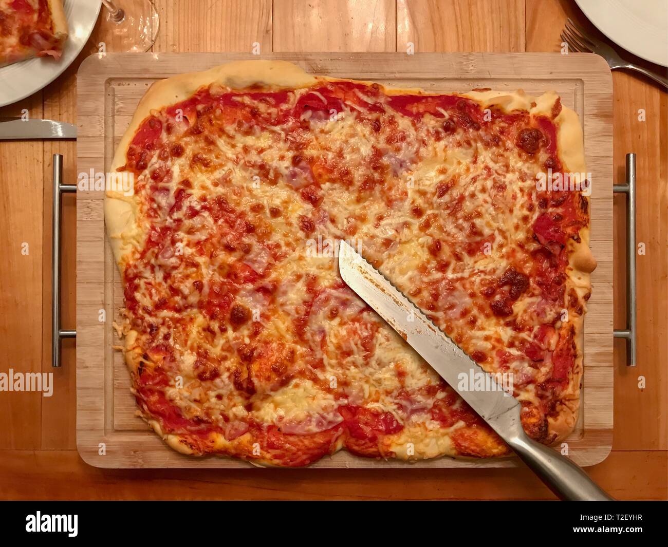 In casa la pizza con pomodori e formaggio sulla tavola di legno, Germania Foto Stock