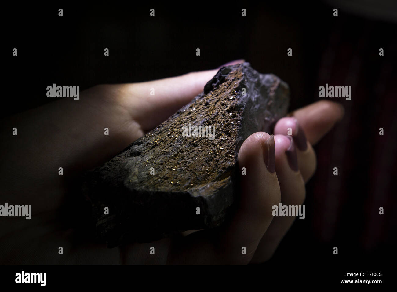 E mano trattiene un residuo di data mining roccia contenente frammenti di argento, stato Shan, Myanmar. Foto Stock