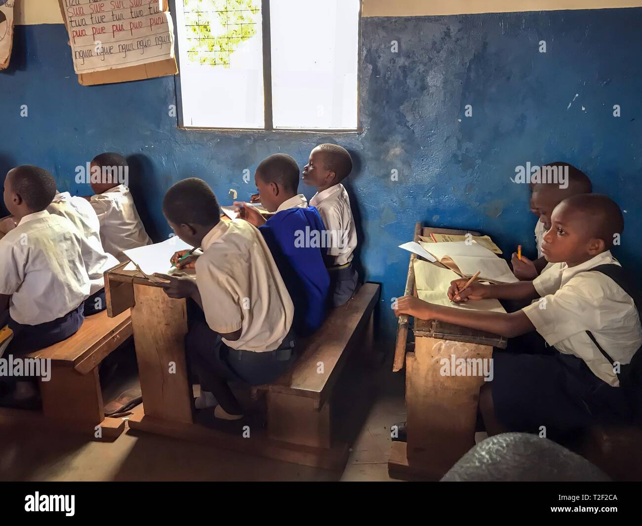 Scuola, lezioni scolastiche, la scuola dei bambini con la scuola vestiti a banchi di scuola, le lezioni in aula, insegnamento frontale, Tanzania Foto Stock
