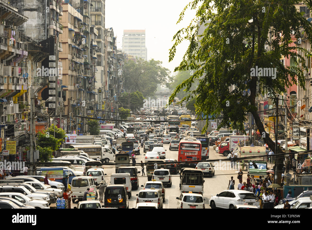 Il traffico giornaliero e la vita della città su strade trafficate di Yangon durante il tramonto. Yangon è la capitale della regione di Yangon Foto Stock
