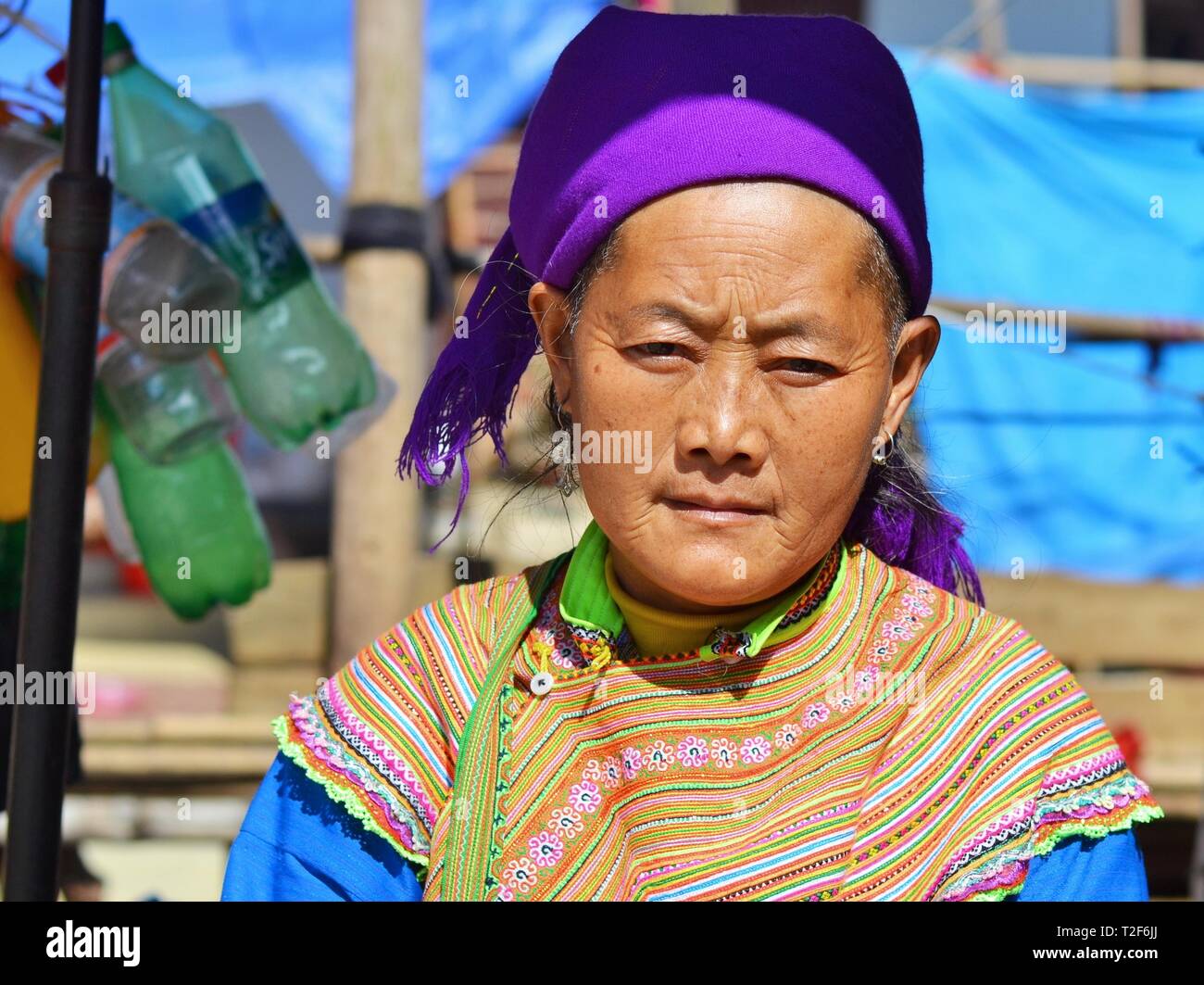 Anziani fiore vietnamita H'mongs donna indossa un colorato fiore tradizionale H'mongs hill-tribe costumi. Foto Stock