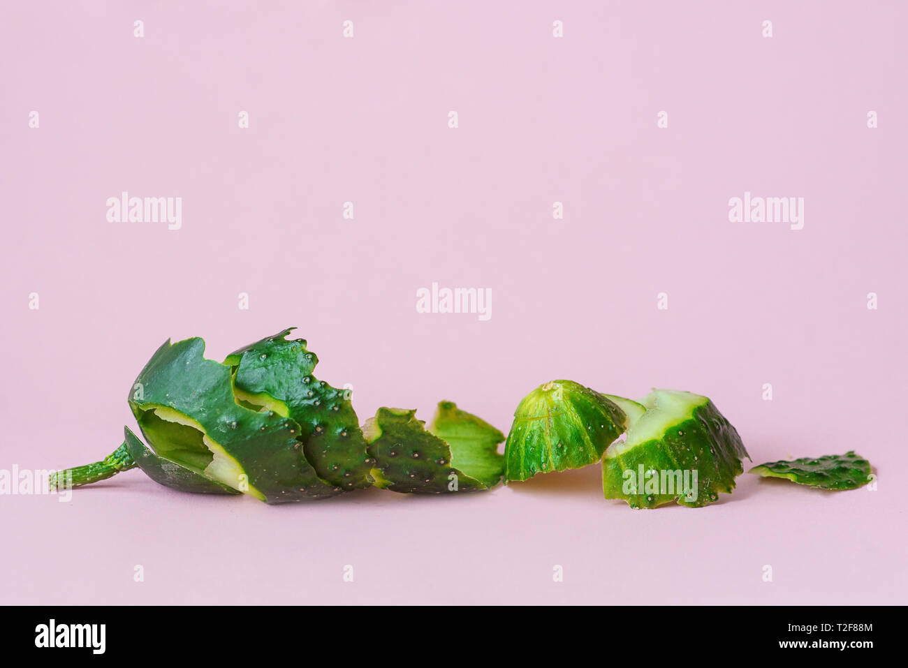 Buccia di cetriolo su sfondo rosa come un simbolo di riciclaggio economia circolare Foto Stock