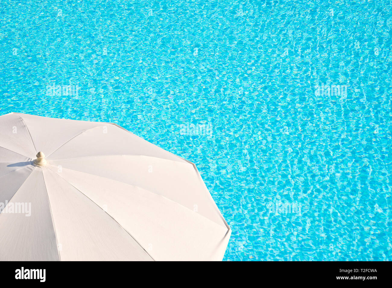 Ombrellone bianco, blu piscina sullo sfondo dell'acqua, concetto di estate Foto Stock