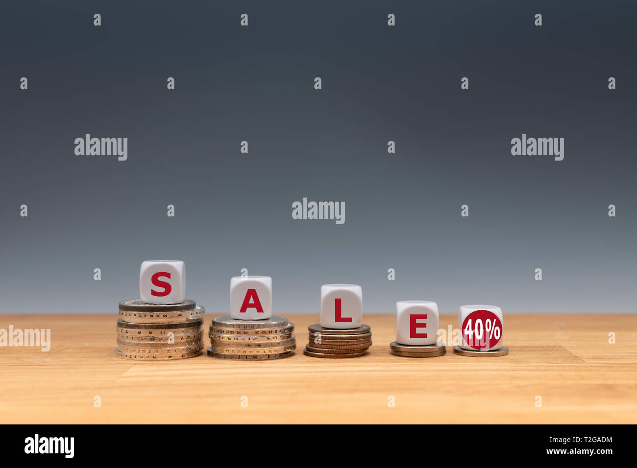 Simbolo per una vendita con un sconto del 40 %. Dadi posti sulle monete formano l'espressione 'sale 40%'. Foto Stock
