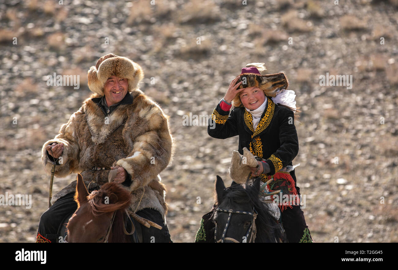 Il bayan Ulgii, Mongolia, 4 ottobre 2015: il kazako eagle cacciatore con sua figlia, eagle cacciatrice Aisholpan, viaggia su i loro cavalli Foto Stock