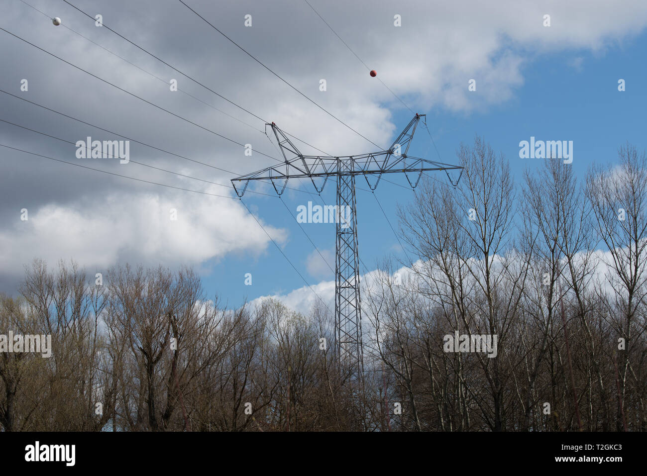 Pilone di elettricità e linee di alimentazione su blu cielo nuvoloso sulla giornata di sole Foto Stock