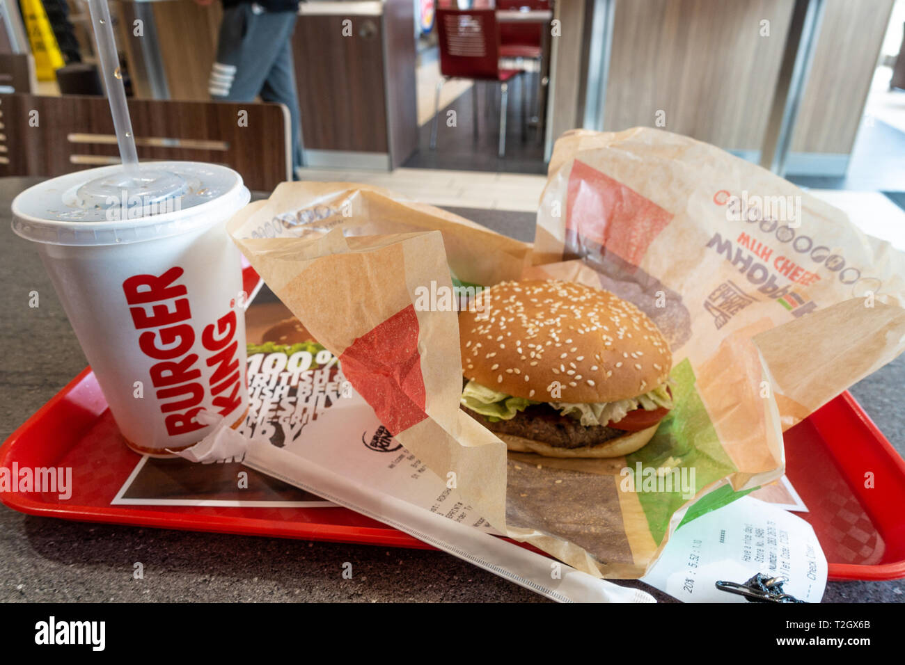 Un whopper meal acquistati presso un Burger King e un ristorante fast food. Un whopper burger e una tazza di soda sono visti su un vassoio su un tavolo. Foto Stock