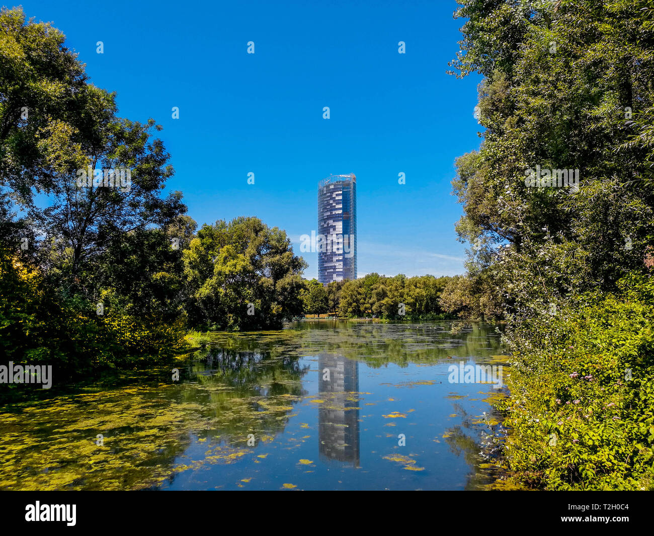 Vista panoramica del post torre, DHL ufficio centrale a Bonn in Germania, che si riflette nel lago del parco Rheinaue, luglio 19, 2018. Parchi a Bonn in Germania. Foto Stock