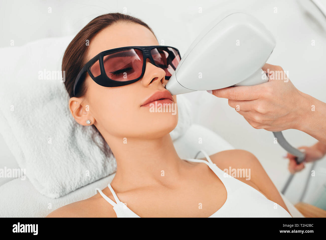 Donna getting Depilazione laser sul suo volto , la rimozione dei peli sulla zona del labbro Foto Stock