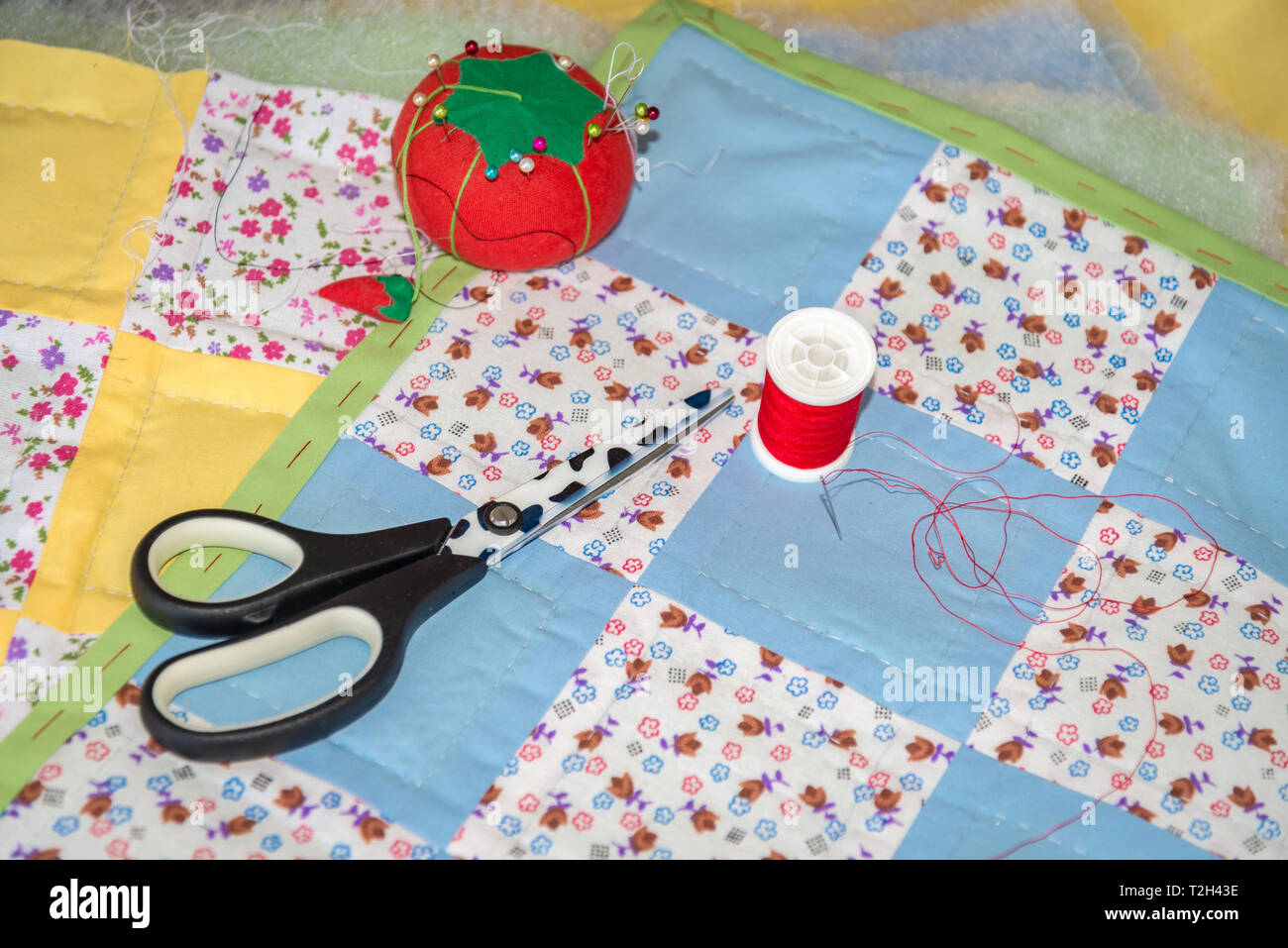 La cucitura di manufatti placemats patchwork con forbici, il pool di thread e cuscino pin Foto Stock