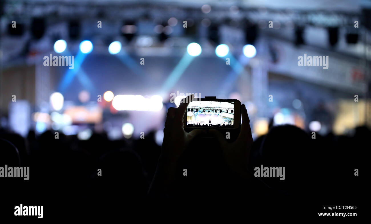 Ragazza la registrazione live del concerto con lo smartphone Foto Stock